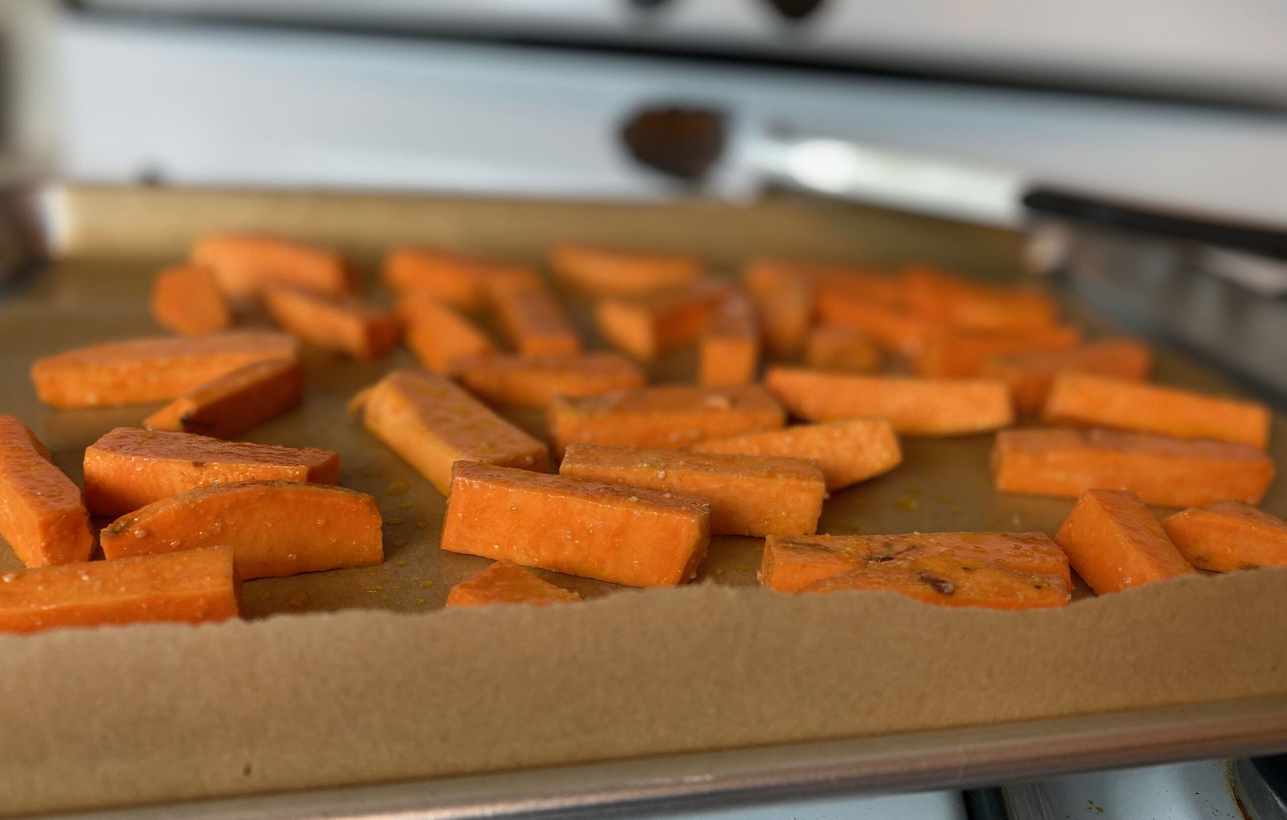 uncooked sweet potato fries on a baking sheet 
