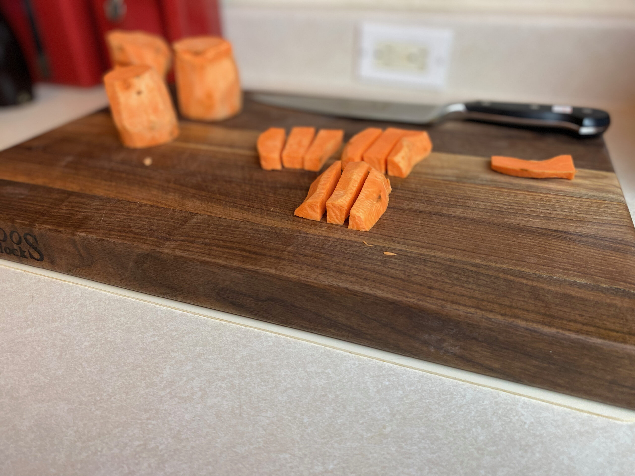 uncooked sweet potato fries on a cutting board