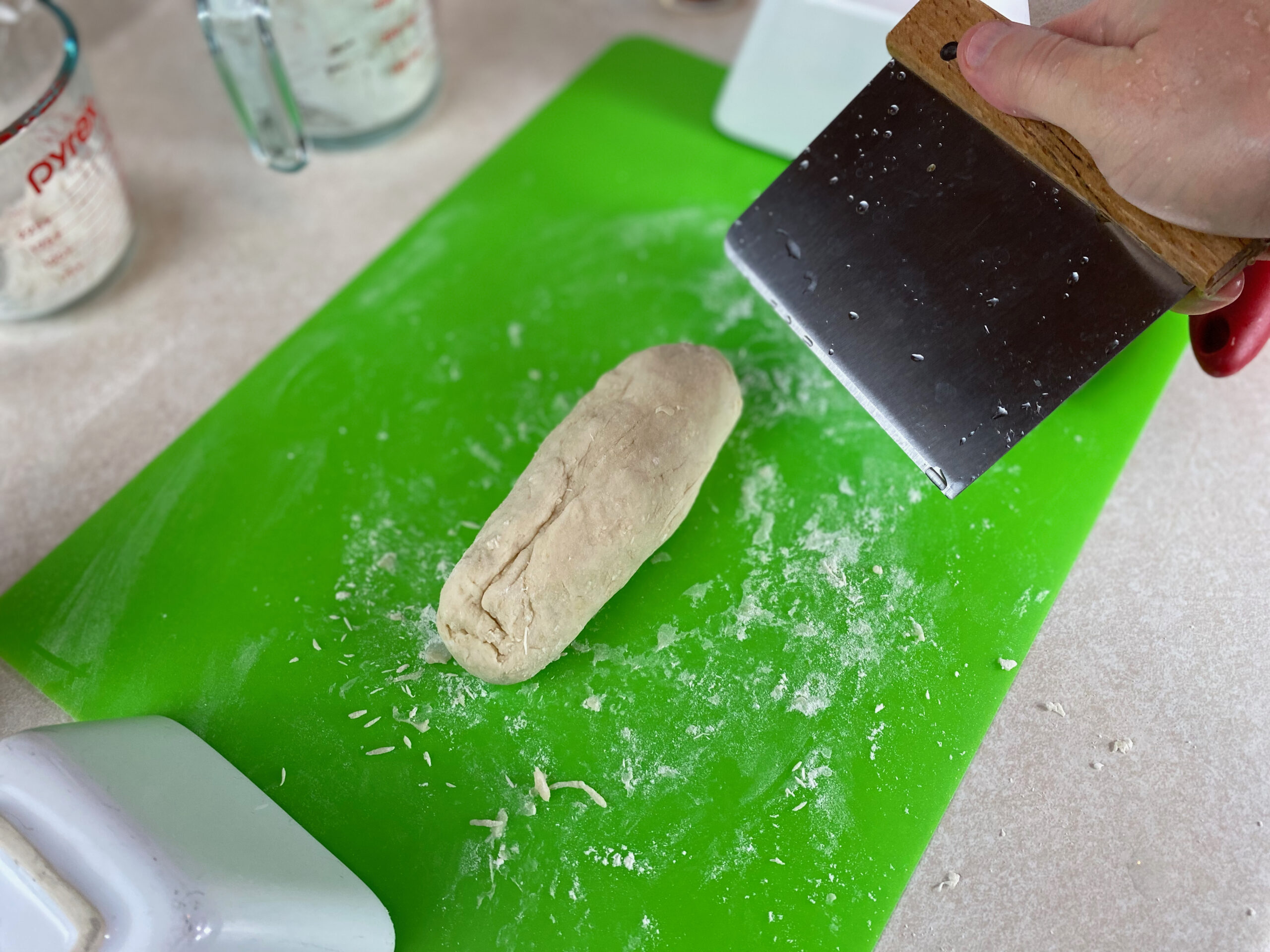 a log of dough about to be cut in half