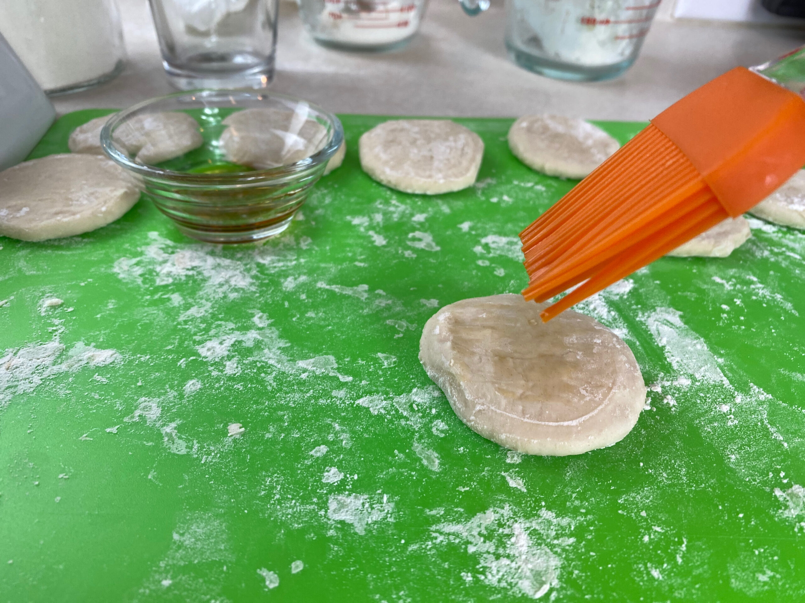 a silicone brush adds sesame oil to a puck of dough