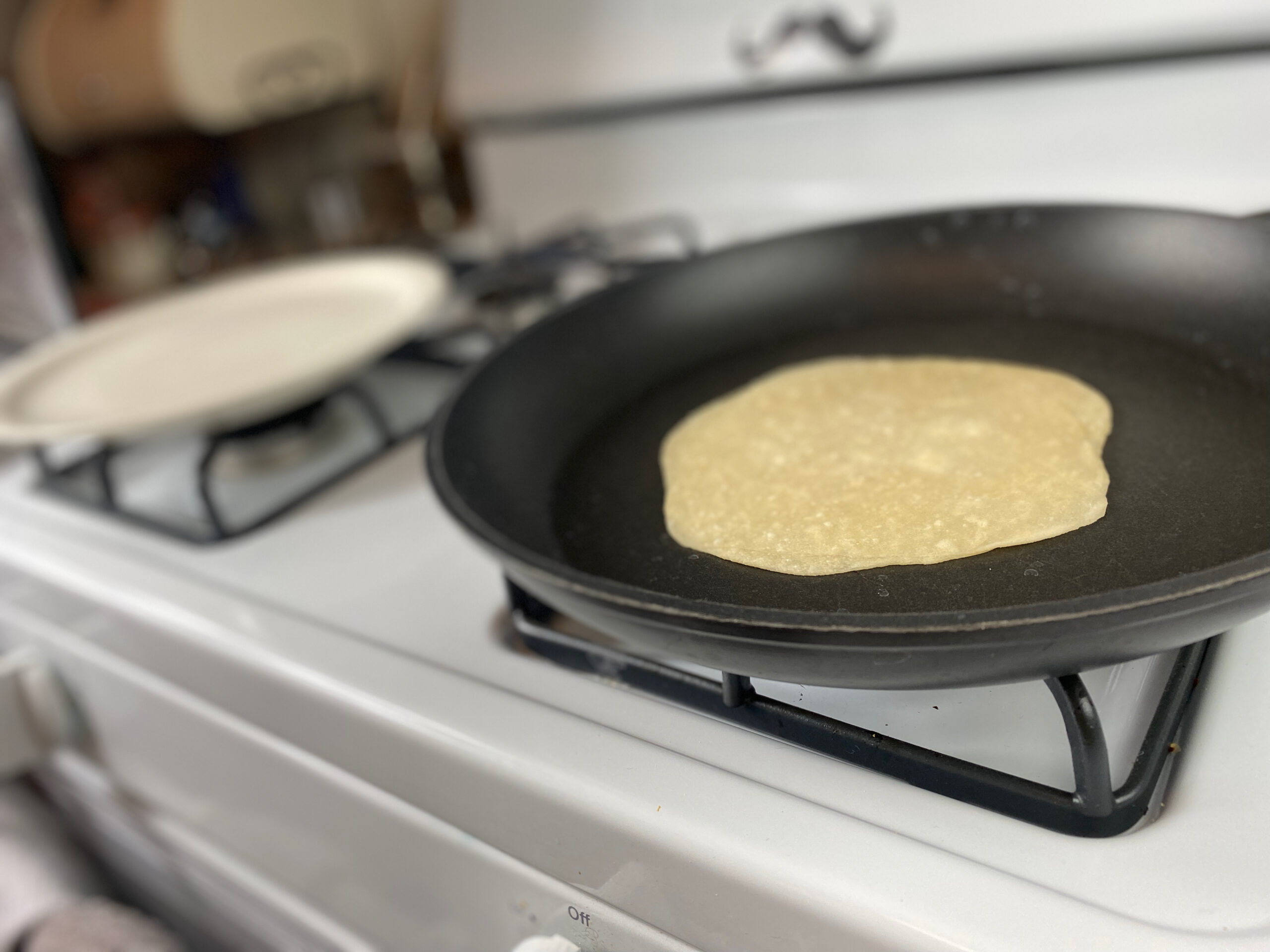 a crepe is cooking in a pan over a stove