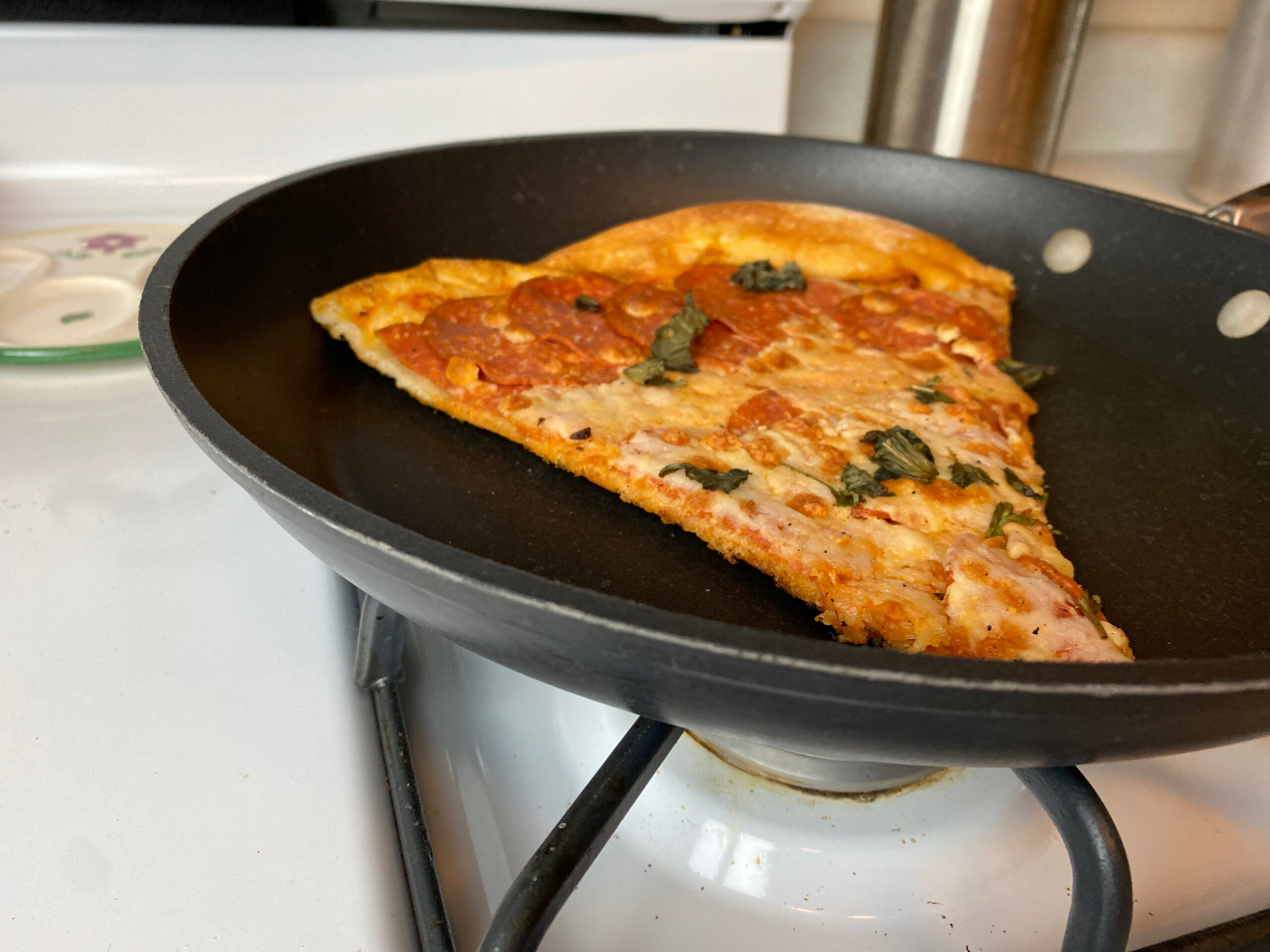 a slice of pizza warming on a pan